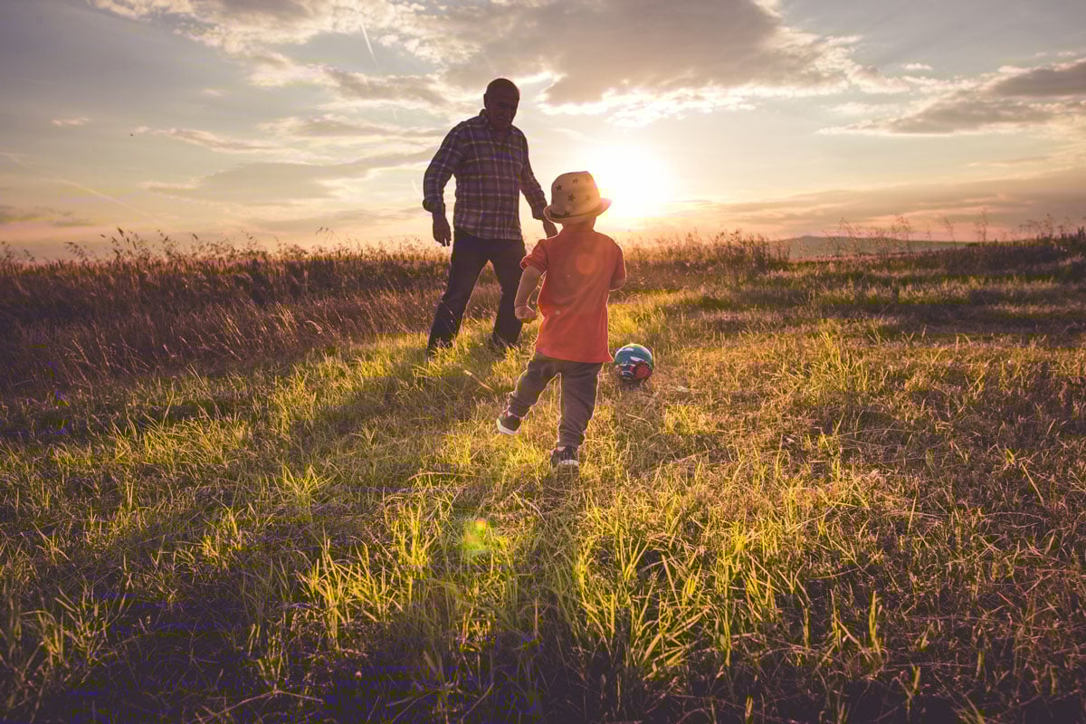 father-and-son-playing-soccer-in-a-field